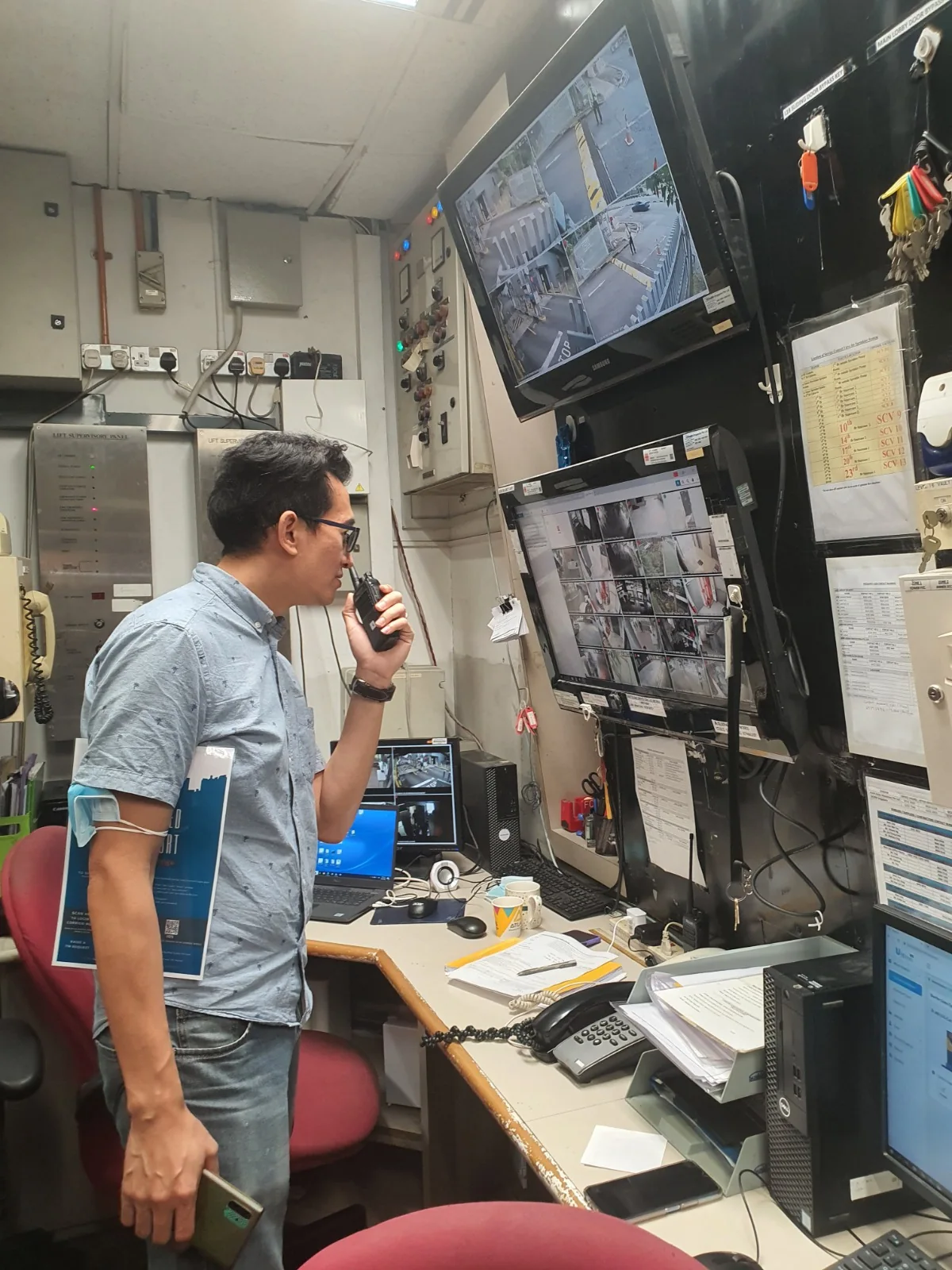 Operator at a desk with CCTV monitoring displays