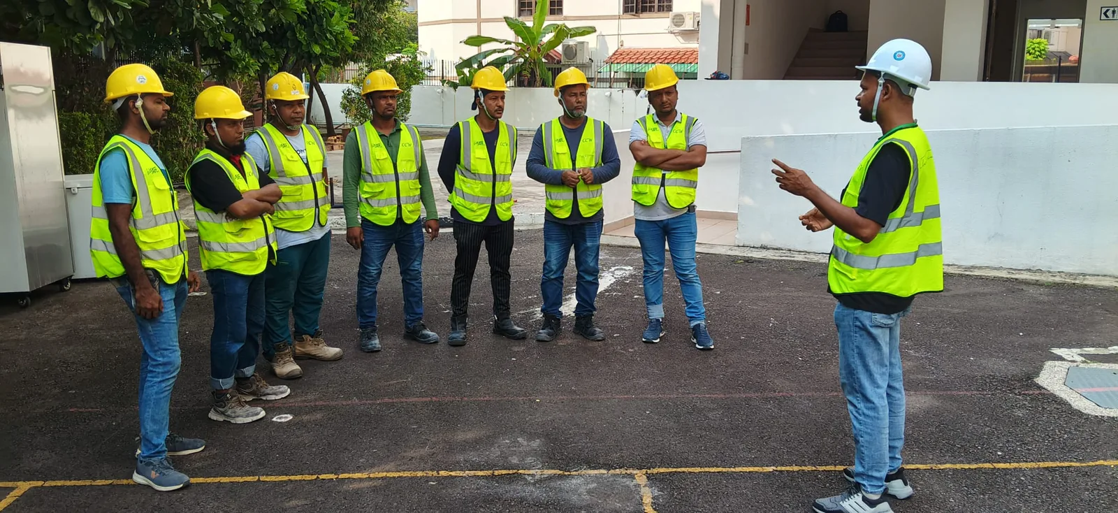 Team members in high-visibility vests attending an outdoor site briefing